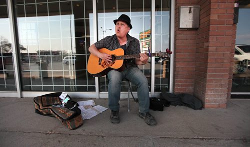 PHIL HOSSACK / WINNIPEG FREE PRESS - Tim (last name refused)  dances to his own tune as he busks out front of the Manitoba Liquor store at Marion and St Mary's Road Friday afternoon. Tim Busks 3 times a week after working his day job and doesn't beleive buskers need lisencing. See story. May 6, 2016