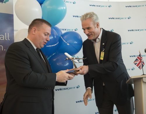 DAVID LIPNOWSKI / WINNIPEG FREE PRESS  Pascal Belanger, Vice President and Chief Commercial Officer, Winnipeg Airports Authority receives a model airplane from Harry Taylor, Executive Vice President and Chief Financial Officer, WestJet, prior to WestJets inaugural flight from Winnipeg to London from Winnipeg Richardson International Airport's gate 6 Saturday, May 7, 2016.