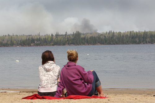 JOE BRYKSA / WINNIPEG FREE PRESS  Cottagers Danica Brigham,left, and Onalee Ames watch as fire burns  on the east end of Caddy Lake in the Whiteshell Monday  , May 09 , 2016.(See Bill Redekop story)