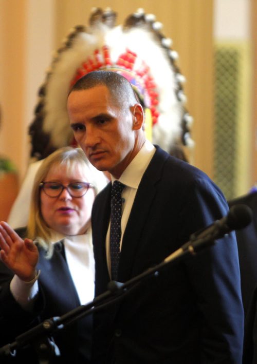 BORIS MINKEVICH / WINNIPEG FREE PRESS NDP MLA oath taking ceremony at the Manitoba Legislature room 200. Kevin Chief with Wabanakwut (Wab) Kinew behind him with head dress. May 9, 2016