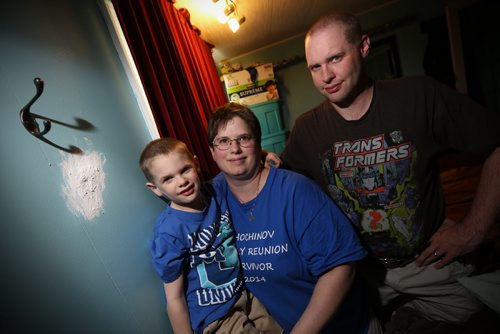 JOHN WOODS / WINNIPEG FREE PRESS Carrie and Shawn Ryland with their son Parker are photographed with a patched bullet hole in the bedroom wall of their trailer home Monday, May 9, 2016.