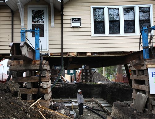 RUTH BONNEVILLE / WINNIPEG FREE PRESS  Farrell Lacquette a worker with Blue Maxx foundations and builders, is dwarfed in size by the house that stands on stilts around him as he works with the rest of his crew to pour a new foundation under a home at 250 Beaverbrook. Standup photo   May 10, , 2016