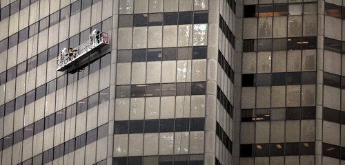 PHIL HOSSACK / WINNIPEG FREE PRESS -  Calling it a day a crew in a suspencer platform makes their way up the Artis buildong at {ortage and Main as a steady rain soaks the structure's panels Tuesday afternoon. Rain was a welcome spring feature to firefighters and farmers in particular. STAND-UP May 10, 2016