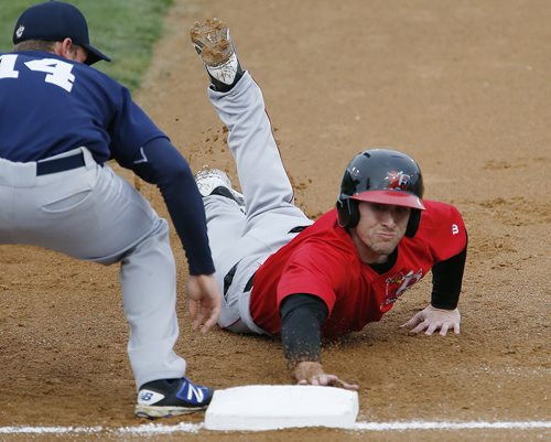 JOHN WOODS / WINNIPEG FREE PRESS Fargo Moorehead Redhawks' Chad Mozingo (3) beats Winnipeg Goldeyes' Jacob Rogers (14) to stay safe on first in Winnipeg Tuesday, May 10, 2016.