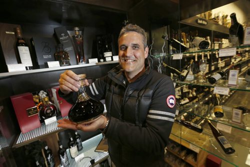 WAYNE GLOWACKI / WINNIPEG FREE PRESS   Ben Rusch, Manager of Product Education, Manitoba Liquor and Lotteries holds a bottle of Graham's Ne Oublie 1882 Port selling for $11,500.00 at the Grant Park Liquor Mart. Geoff Kirbyson  story  May 13  2016
