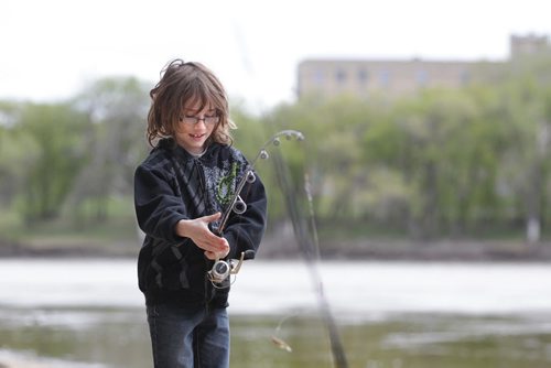 RUTH BONNEVILLE / WINNIPEG FREE PRESS  Nine-year-old Cade Cameron gets ready to cast his line along the banks of the Assiniboine River at the junction of the Red at the Forks on the opening day of the start of the fishing season in Manitoba Saturday.  His dad Cory Cameron hadn't caught anything yet but enjoy spending the day fishing together. Standup photo.   May 14, , 2016
