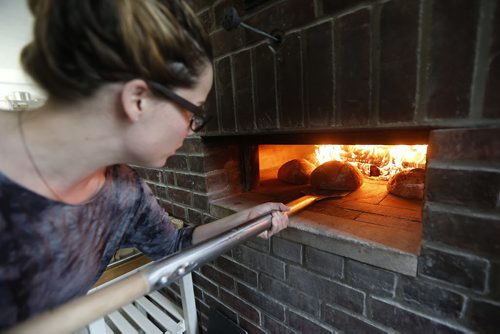 JOHN WOODS / WINNIPEG FREE PRESS Suzanne Gessler, owner of Pennyloaf Bakery on Corydon attends to some bread in their wood fired oven Sunday, May 15, 2016.