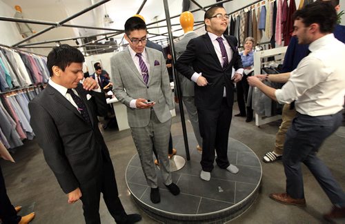 PHIL HOSSACK / WINNIPEG FREE PRESS -  SUITS FOR GRADS - Dapper Day - Left to right Raymond Flett, Kashtin Mekish and Jimmy Boulanger admire their transformation as Alex Ethan (right) puts the finishing touches on thier new prom suits Monday. A couple of dozen graduating from Children of the Earth School are being given fitted suits for their Grad. See Alex Paul's story.  May 16, 2016