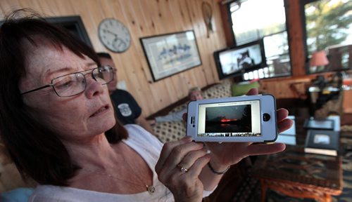 PHIL HOSSACK / WINNIPEG FREE PRESS -  Sandy Fisette shows off photos taken across Caddy Lake's Green Bay of the fire that forced their evacuation. Her husband Grant is a volunteer firefighter who fought to insure the saftey of cottages. See Alex Paul story.  May 16, 2016