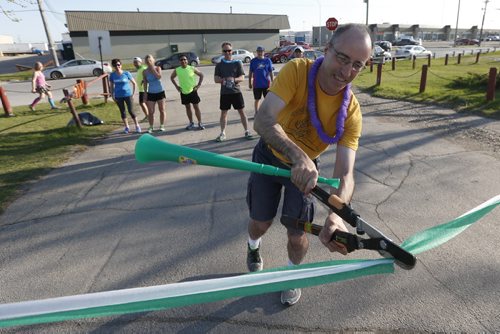 JOHN WOODS / WINNIPEG FREE PRESS Aldo Furlan cuts the ribbon to kick off runners in Pop-Up The Hill, a pre-run for September's Ted's Run For Literacy, at Westview Park (a.k.a. Garbage Hill) Tuesday, May 17, 2016.