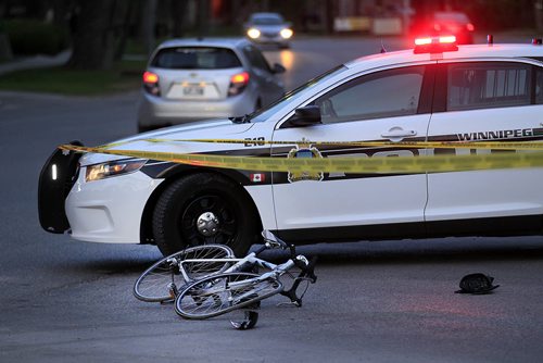 PHIL HOSSACK / WINNIPEG FREE PRESS -  A bent cycle lays beside a police cruiser protecting the scene of a car cyclist accident at Wellington and Grosvenor Wednesday night. May 18, 2016