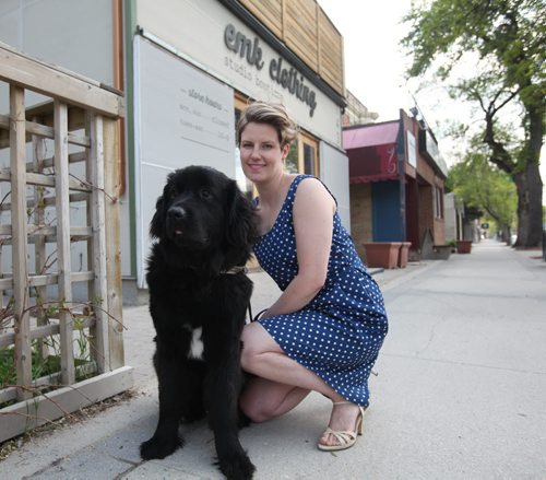 RUTH BONNEVILLE / WINNIPEG FREE PRESS  Threads: EMK clothing at 143 Sherbrook with owner Eron Kembel and her dog Marigold.  She models one of her designs - Nora Dress in blue polka dot, in front of her store with her dog.   Column is about local clothing designer Erin Kembel with EMK clothing features Mia & Moss cashmere denim jeans to compliment her tops and clothing line.     May 19, , 2016