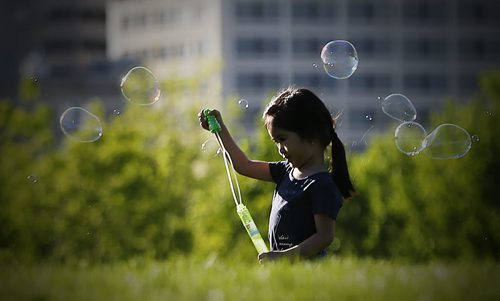 JOHN WOODS / WINNIPEG FREE PRESS Rylee Delacruz plays with bubbles at the Forks with her parents Rudy and Genelee Monday, May 23, 2016.