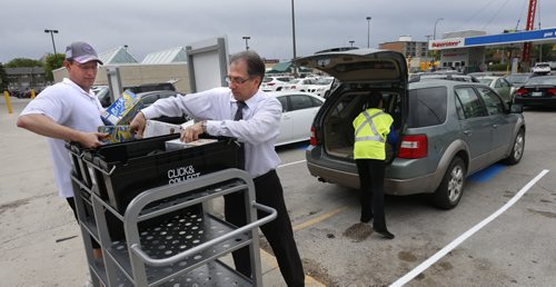 WAYNE GLOWACKI / WINNIPEG FREE PRESS    In centre, Borys Plante, Click-and-Collect Manager helps Rick Morris load groceries into his vehicle Tuesday. This is part of  the Real Canadian Superstore's soft launch of their new Click-and-Collect service they will start to offer to customers Wednesday. Loblaw is launching its Click-and-Collect service in two Winnipeg Superstores including this location at 3193 Portage Ave. Customers can place their order online, a store employee will fill it, and the customer can drop by the store later and pick it up.   Murray McNeill  May 24   2016