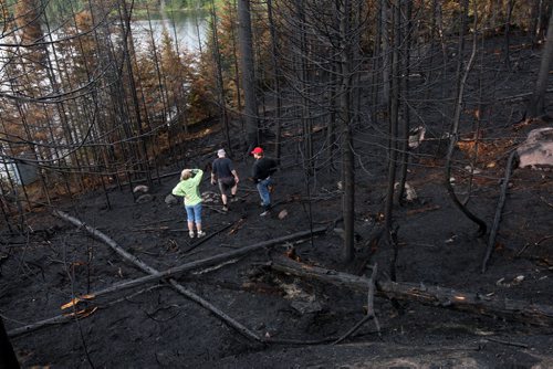 JOE BRYKSA / WINNIPEG FREE PRESS  Florence Lake cottagers surveys the burnt out shores of neighboring Nora Lake for the first time Tuesday- Already new growth is coming up from the ashes , May 24 , 2016.(see Nick Martin  story)