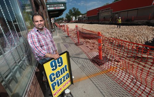 PHIL HOSSACK / WINNIPEG FREE PRESS -  Amar Aziz poses in front of his 99cent Pizza, one of two outlets he owns on Selkirk ave. THe normally busy avenue is now completely closed due to construction and Amar and other business owners are suffering. See Rany Turner story.  May 24, 2016
