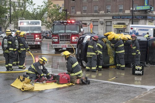 DAVID LIPNOWSKI / WINNIPEG FREE PRESS  Winnipeg Fire and Paramedics help occupants of a turned over van escape through the windshield at the corner of Rupert Ave and Main Street during rush hour traffic Wednesday May 25, 2016.
