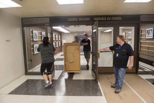 DAVID LIPNOWSKI / WINNIPEG FREE PRESS  Holly Schwenzer (left) and Wayne Burch of the city of Winnipeg hold the doors open for Rick Schwenzer and Eric Dienstbier of Winnipeg small moving specialists as they move office equipment from the Council building to the Administration building through the underground tunnel Wednesday May 25, 2016 while the Council building undergoes renovations .