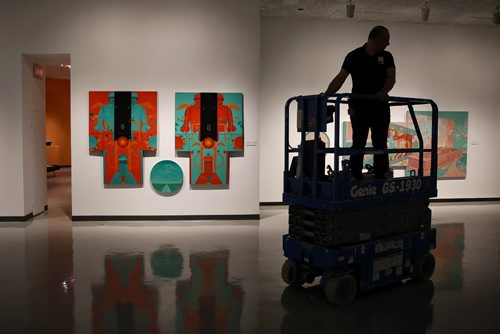 MIKE DEAL / WINNIPEG FREE PRESS  A WAG employee clears out the scissor lift before the opening of two exhibitions featuring 20th-century artist Marc Chagall and Esther Warkov one of Manitoba's most distinctive painters.  In the background is Warkov's Night Riders, 1971, oil on canvas.   160526 Thursday, May 26, 2016