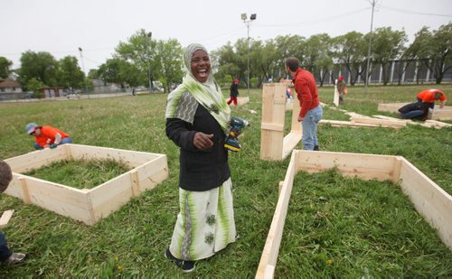RUTH BONNEVILLE / WINNIPEG FREE PRESS  Shamso Muhammad from the Congo is happy with herself after learning how to use a drill for the first time to make a wooden garden bed along with other newcomers in her community in North End Park Saturday.   See Carol Sanders story.   May 28, , 2016