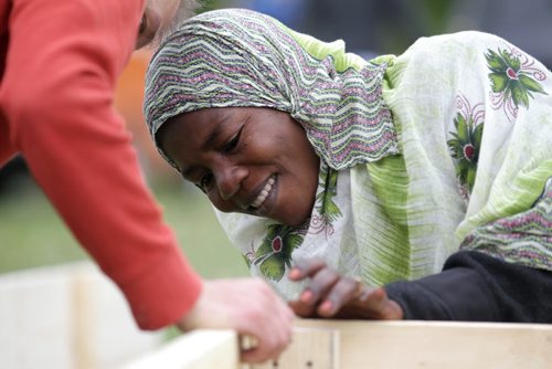 RUTH BONNEVILLE / WINNIPEG FREE PRESS  Shamso Muhammad from the Congo learns how to use a drill with the help of volunteer Philippe Lagacé-Wiens  to make a wooden garden bed along with other newcomers in her community in North End Park Saturday.   See Carol Sanders story.   May 28, , 2016