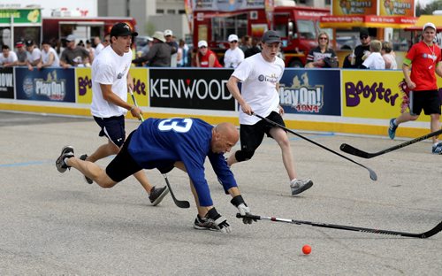 TREVOR HAGAN / WINNIPEG FREE PRESS Rick Downey of the, Four Points by Sheraton Winnipeg South is tripped up as he plays against the True North Foundation team during the Play On 4 on 4 street hockey tournament at the University of Manitoba, Saturday, May 28, 2016.