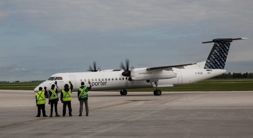 MIKE DEAL / WINNIPEG FREE PRESS The ground crew waves goodbye at the Porter Airline flight for Toronto leaves Winnipeg. 160529 - Sunday, May 29, 2016