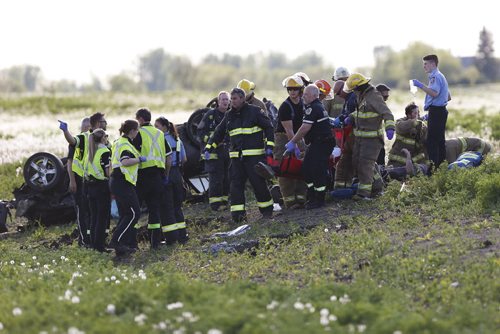 JOHN WOODS / WINNIPEG FREE PRESS Emergency crews attend to injured persons involved in a MVC rollover on Inkster Blvd just west of Klimpke Road Sunday, May 29, 2016.