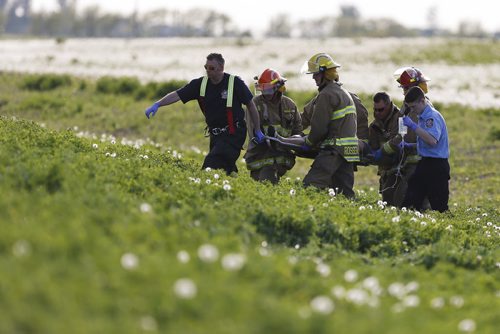 JOHN WOODS / WINNIPEG FREE PRESS Emergency crews attend to injured persons involved in a MVC rollover on Inkster Blvd just west of Klimpke Road Sunday, May 29, 2016.