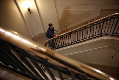 MIKE DEAL / WINNIPEG FREE PRESS  It's budget day, but it's business as usual for Fana Aklilu one of many in the building services cleaning crew who was out polishing the brass banisters of a stairway in the legislative building Tuesday morning.   160531 Tuesday, May 31, 2016