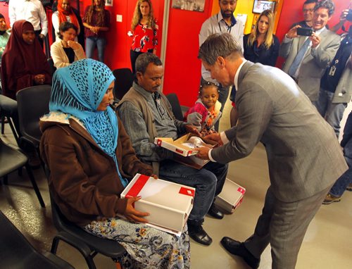 BORIS MINKEVICH / WINNIPEG FREE PRESS Finance Minister Cameron Friesen at Welcome Place. 5 year old newcomer from Eritrea (via Sudan) Senat Tewelde got a pair of shoes from the Finance Minister. He broke the tradition of putting on a new pair of shoes for himself and gave 3 pairs of shoes to the new family. Only one of the three kids were present with the parents (no first names released) at the event. The minister spoke to the family through an interpreter. Budget day photo opportunity. May 30, 2016.