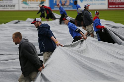 JOHN WOODS / WINNIPEG FREE PRESS The field crew removes the rain trap prior to the game between the Winnipeg Goldeyes and Sioux Falls Canaries in Winnipeg Tuesday, May 31, 2016.