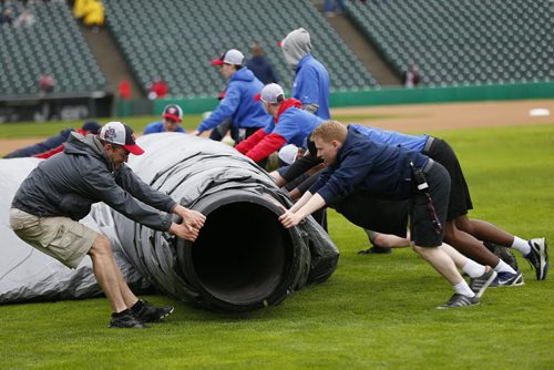 JOHN WOODS / WINNIPEG FREE PRESS The field crew removes the rain trap prior to the game between the Winnipeg Goldeyes and Sioux Falls Canaries in Winnipeg Tuesday, May 31, 2016.