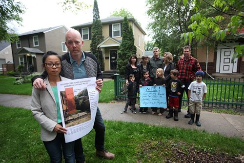 RUTH BONNEVILLE / WINNIPEG FREE PRESS  Niagara Street Residents Rachel and Kelly Larkins along with other residents supporting them, hold poster showing spot where MTS plans on erecting 18M tower that they are protesting due to the close vicinity of children and residential homes in area tower to be erected in fenced lot directly behind group of residents are standing 10 feet from neighbours lot).  The Larkins have over 400 signed petitions so far and over 200 online after a week of petitioning.   See story.    June 01, 2016