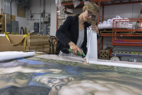 ZACHARY PRONG / WINNIPEG FREE PRESS  Alex Vanderhooft trims a reproduction of artwork from the Sistine Chapel at Valley Fashions on Monday, May 30, 2016.