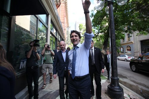 RUTH BONNEVILLE / WINNIPEG FREE PRESS  Prime Minister Justin Trudeau waves as he walks down McDiarmid Ave. with WFP editor Paul Samyn just before heading into the  Winnipeg Free Press News Cafe Thursday.   June 02 / 2016