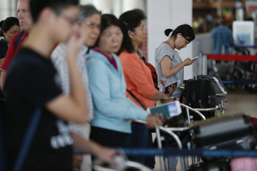JOHN WOODS / WINNIPEG FREE PRESS Air China passengers wait to check-in to board a plane out of Winnipeg Sunday, June 5, 2016. Passengers from an Air China had to make an unscheduled stop in Winnipeg when their flight made an emergency landing last night.