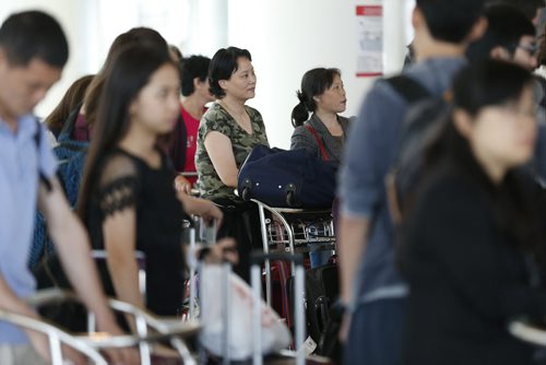 JOHN WOODS / WINNIPEG FREE PRESS Jian Wyatt (C) and other Air China passengers wait to check-in to board a plane out of Winnipeg Sunday, June 5, 2016. Passengers from an Air China had to make an unscheduled stop in Winnipeg when their flight made an emergency landing last night.