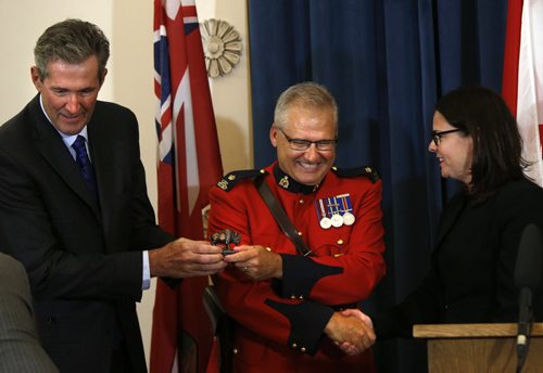 In centre, Insp. RCMP Paul Saganski accepts the Order of the Buffalo Hunt  from Premier Brian Pallister and is congratulated by Heather Stefanson,  Minister of Justice and Attorney General at a ceremony in the Manitoba Legislative Bld. Tuesday.  Paul accepted the honour on behalf of the 65 members of the RCMP "D" Division that were deployed to Fort McMurray, Alberta at the height of the wildfires.   The Order of the Buffalo Hunt is the highest honour the province can bestow to individuals who have demonstrated outstanding skills in the areas of leadership, service and community commitment. Aidan Geary story.   June 7  2016