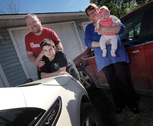 PHIL HOSSACK / WINNIPEG FREE PRESS -   Tyson Beasley poses with his wife April Fields, their  son Andrew (14) and daughter Abigail (4 mo) with their pair of Electric "Volt" cars which will now be charged via a solar array on the couple's garage. See Murray McNeill story.  June 7, 2016.
