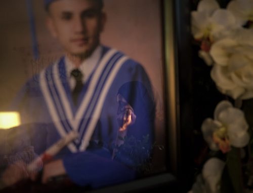 ZACHARY PRONG / WINNIPEG FREE PRESS  Tavga Ahmeds reflection is seen on a photo of her son Mohammed Omar at her home in Winnipeg on June 7, 2016. Mohammed was murdered in Saskatoon on April, 24, 2016.
