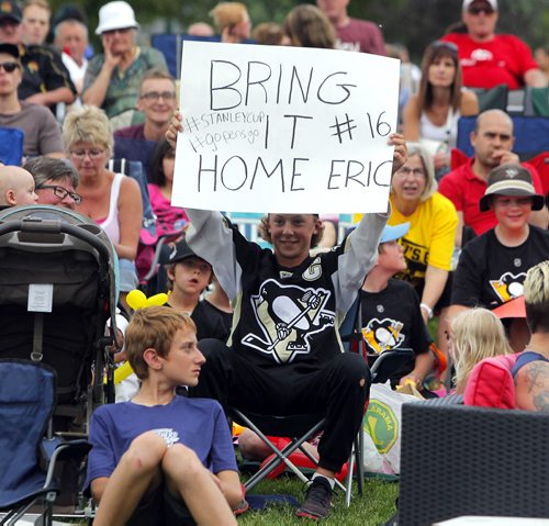 BORIS MINKEVICH / WINNIPEG FREE PRESS Winkler, MB - HOCKEY NIGHT IN WINKLER - Eric Fehr fan TJ Matuszewski holds a sign while he cheers on the Penguins in Bethel Heritage Park. June 9, 2016.