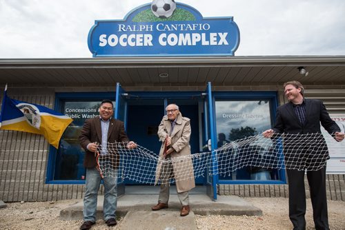 MIKE DEAL / WINNIPEG FREE PRESS Ralph Cantafio prepares to cut a soccer net to officially rename the Winnipeg Waverley Soccer Complex to the Ralph Cantafio Soccer Complex in his honour Sunday morning. He is flanked by Winnipeg City Councillor Mike Pagtakhan (left) and Matthew Duffy with the Winnipeg Soccer Federation (right). 160612 - Sunday, June 12, 2016