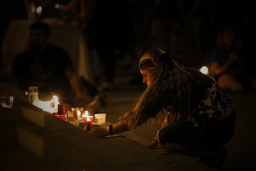 JOHN WOODS / WINNIPEG FREE PRESS A woman places her candle as people participate in a vigil as the names of the Orlando shooting victims  line the steps of the Manitoba Legislature Monday, June 13, 2016.