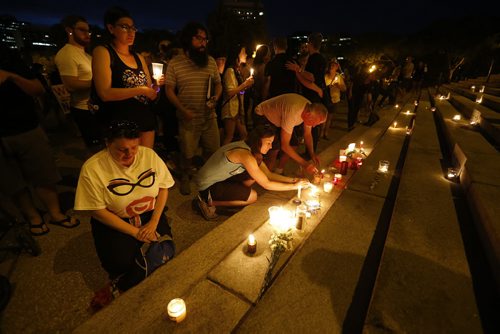 JOHN WOODS / WINNIPEG FREE PRESS People place their candles at a vigil as the names of the Orlando shooting victims  line the steps of the Manitoba Legislature Monday, June 13, 2016.