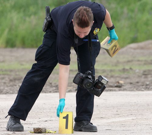 JOE BRYKSA / WINNIPEG FREE PRESS.Police Identification Officer collects evidence on the east side of Taylor Ave Sobeys- Their was a report of a person with a gun in the area earlier with possible shots fired , June 15, 2016  -(See story)