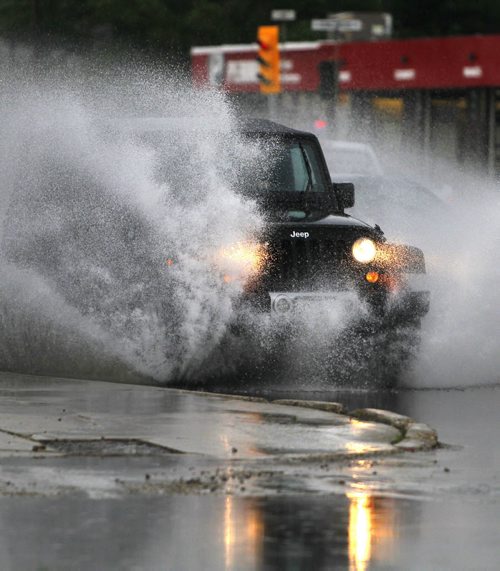 BORIS MINKEVICH / WINNIPEG FREE PRESS A jeep plows through the flooded St. Annes Road near Regal Ave. Early morning thunder storms dumped rain on the city. June 17, 2016.