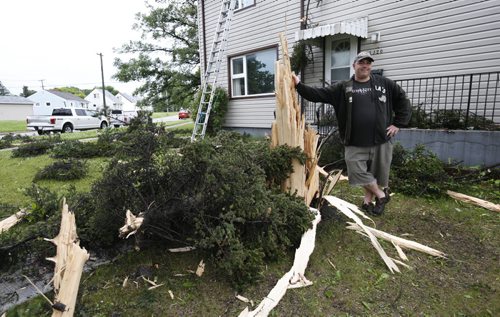 WAYNE GLOWACKI / WINNIPEG FREE PRESS   Adam Mack by the stump of a spruce tree in front of his duplex in the 1900 block on Corydon Ave. Friday morning after the tree was hit by lightning. No one was injured. Kevin Rollason story    June 17  2016