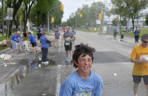 ZACHARY PRONG /  WINNIPEG FREE PRESS  A runner in the Manitoba Marathon cools down in a sprinkler on June 19, 2016.