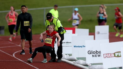 TREVOR HAGAN / WINNIPEG FREE PRESS Bib 6487- Jade - Half marathon A 2016 Manitoba Half Marathon participant Jade Blando of Winnipeg collapses just short of the finish line. She would try to crawl the rest of the way, but had to be helped into a wheelchair, Sunday, June 19, 2016.